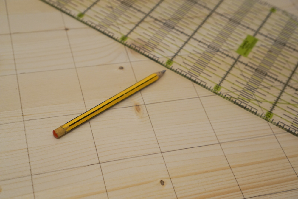 Löcher im Abstand von 5 cm auf Holzbrett anzeichnen.
