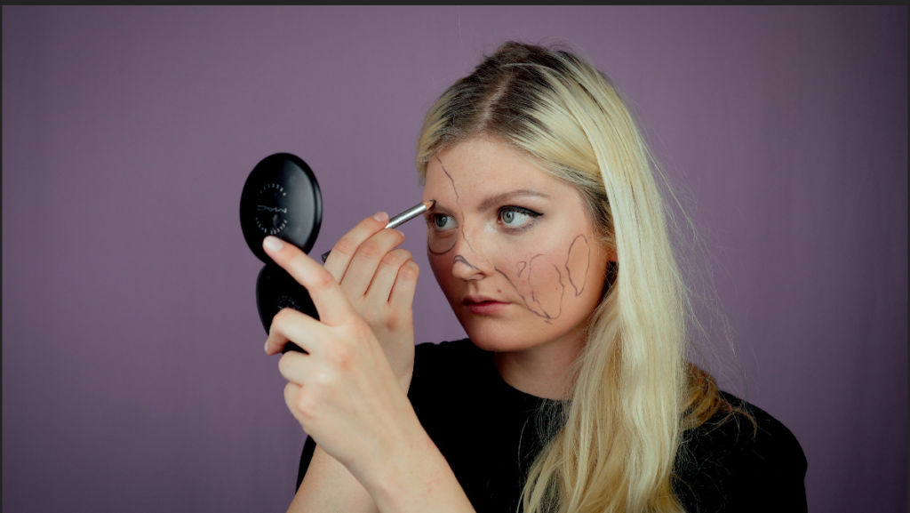 Auf der Halloween Makeup Gesichtshälfte werden mit dem Kayal Orientierungslinien eingezeichnet.