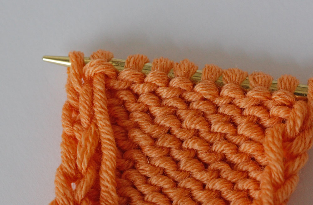 Randmaschen stricken: Bei der Kettmasche wird die letzte Masche einer Reihe wie zum Linksstricken abgehoben.