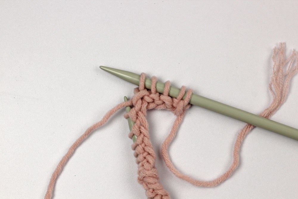 Schal stricken. Die Hinreihe beginnt nach den beiden I-Cord-Maschen mit drei rechten Maschen.