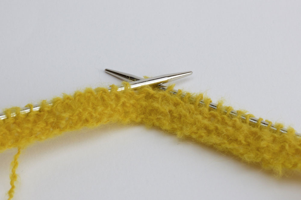 BubbleLoop - Der untere Rand des Loops wird in Ocker kraus rechts gestrickt.
