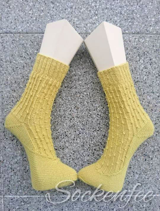 Die Sockenfee hat die BeritSocks in zartem Gelbton mit Bumerangferse probegestrickt.