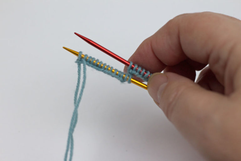 Strümpfe stricken: Nachdem die Maschen auch auf Nadel zwei aufgenommen sind, kommt die dritte Nadel hinzu.