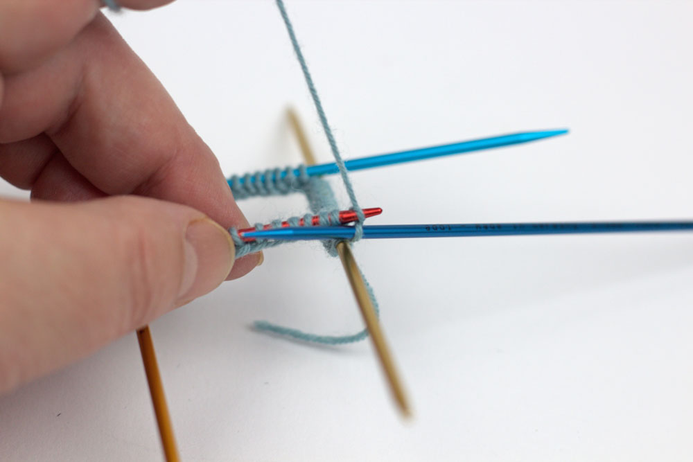 sockshypeSockenstricken-KAL - Mit der 5. Nadel werden jetzt die Maschen der ersten Nadel im Bündchenmuster abgestrickt.