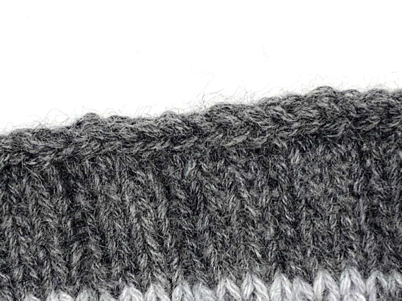 Der Kordelrand am oberen Rand des Cowls mit Jacquardmuster