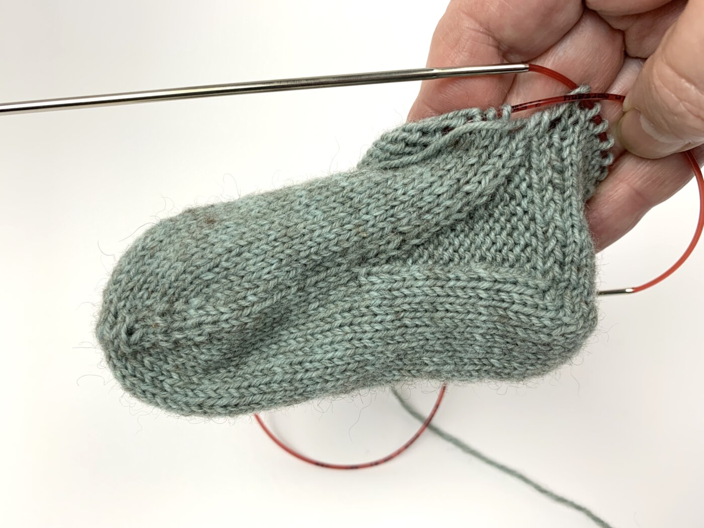 Toe Up Socken stricken für Babys und Kinder - Die Ferse ist fertig. Du siehst die linken Spickelmaschen, die Rundung der Ferse, die Fersenwand.