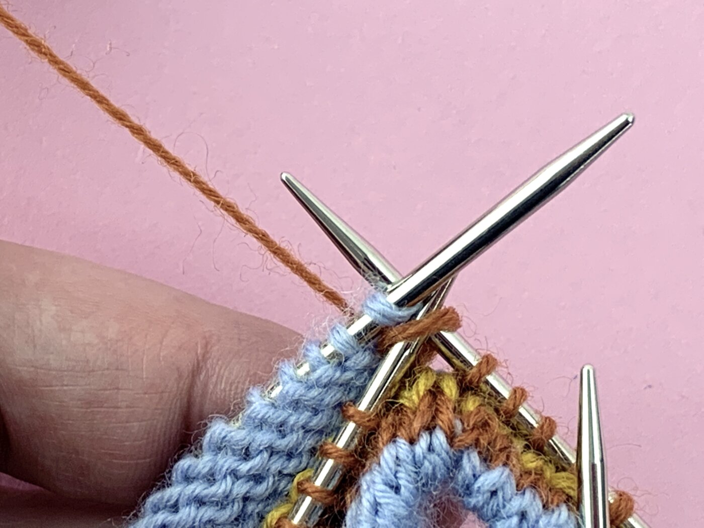 Die Maschen auf beiden Nadeln werden zusammengestrickt.