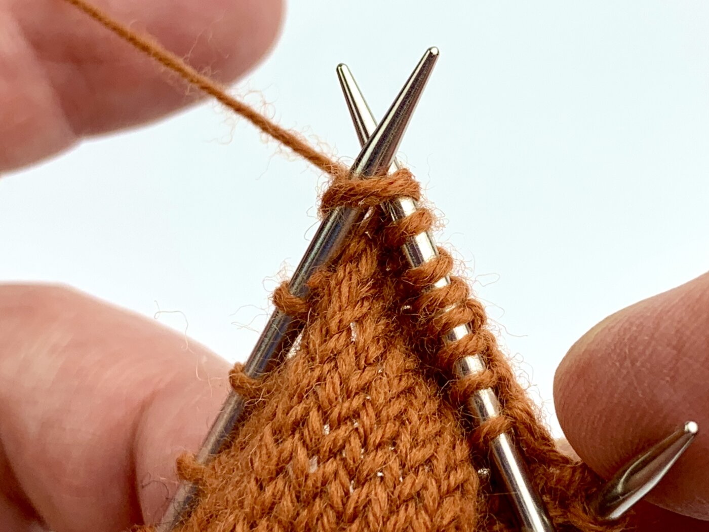 Nun werden Tochter- und Mutterma-sche rechts zusammengestrickt.  