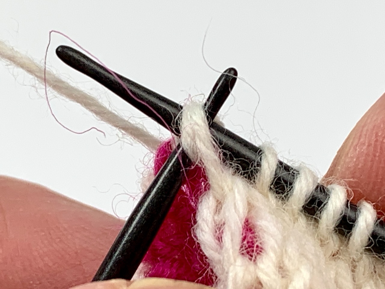 Socken stricken mit zwei Nadeln: Auf der Vorderseite werden die Knötchen der Rückseite mit den Randmaschen zusammengestrickt.