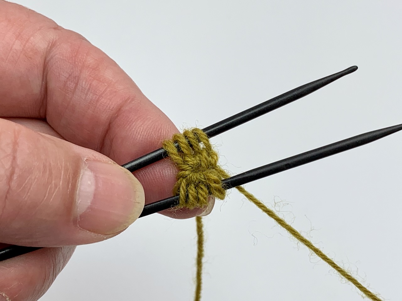 Die Maschen sind auf zwei Nadeln verteilt. Der Fadenring wurde geschlossen. Dadurch entsteht eine schöne Rosette für die Propellerspitze toe up.